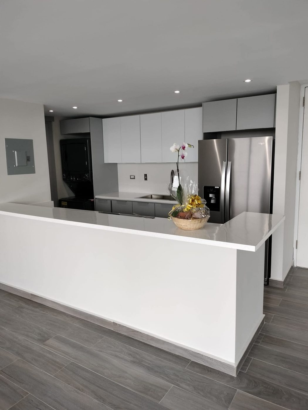 Cocina moderna con gabinetes grises y barra blanca